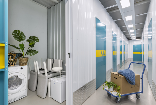 Hublibox Spreitenbach – Hallway with turquoise doors and washing machine in storage unit